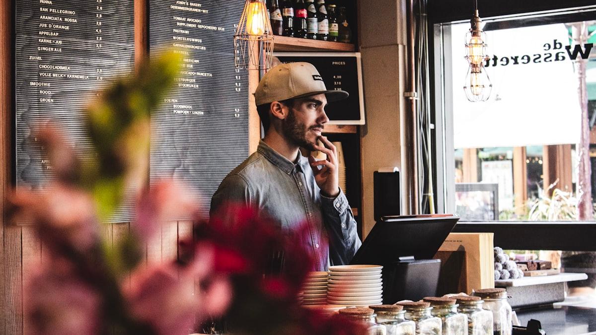 A cafe owner standing at the counter of their shop